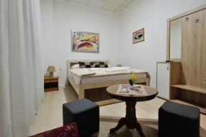 a bedroom with a bed and a table and chairs at Motel Edem in Mostar