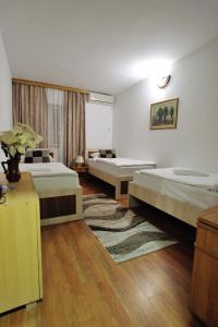 een hotelkamer met 2 bedden en een tapijt bij Motel Edem in Mostar