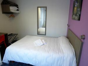 サン・タヴェルタンにあるHotel le Faisanのベッドルーム(鏡付きの白いベッド付)