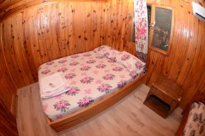 a small room with a bed in a wooden room at Olympos Camlık Pension in Olympos