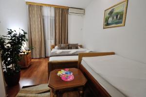 a hotel room with two beds and a table at Motel Edem in Mostar