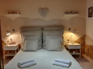 a bedroom with a bed with white sheets and pillows at Nicole House in Bari