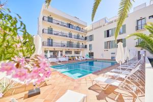 a hotel with a swimming pool and chairs and a building at Cupido Boutique Hotel in Paguera