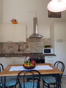 a kitchen with a table with a bowl of fruit on it at Agriturismo VILLA MOZART nel verde in Gubbio