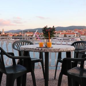 a table with four chairs and two drinks on it at Seaside Apartment Franica in Vela Luka