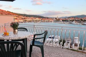 a table and chairs on a balcony with a view of a harbor at Seaside Apartment Franica in Vela Luka