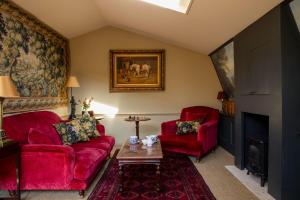 a living room with two red chairs and a fireplace at Hazlitt's in London