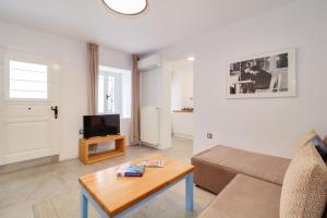 uma sala de estar com um sofá e uma mesa em Athens Residence Apartments em Atenas