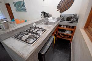 cocina con fogones horno superior junto a un microondas en Villas Sur Mer, en Negril