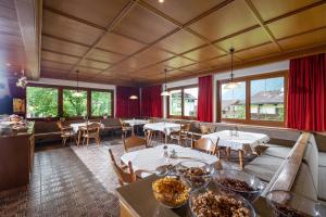 un restaurante con mesas, sillas y ventanas en Pension Kumbichlhof, en Mayrhofen