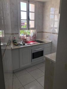 a white kitchen with a sink and a window at Parque Santiago II Tenerife in Arona