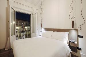 a bedroom with a large white bed and a window at Tornabuoni View in Florence
