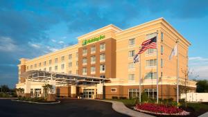 a hotel with an american flag in front of it at Holiday Inn Indianapolis Airport by IHG in Indianapolis