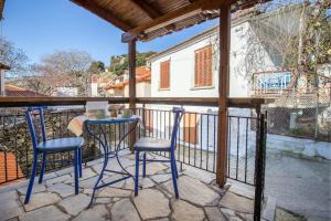 a patio with two chairs and a table on a balcony at Lazaros Maria in Mariaí