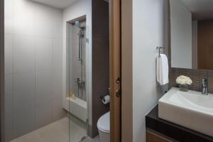 a bathroom with a sink, mirror, and toilet at Citadines Sukhumvit 8 Bangkok - SHA Extra Plus Certified in Bangkok