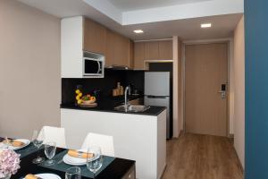 uma cozinha com uma mesa com cadeiras e um balcão em Citadines Sukhumvit 8 Bangkok em Banguecoque