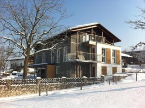 a house in the snow with a stone fence at Ferienwohnungen Wagenstaller in Söllhuben