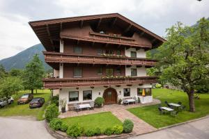 a large house with a balcony and a yard at Pension Kumbichlhof in Mayrhofen
