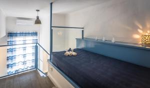 a bedroom with a blue bed and a window at Scricciolo in Viareggio