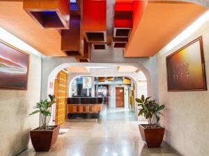 a hallway with two potted plants in a building at Hotel Antas in Mexico City