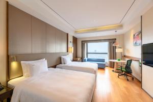 a hotel room with two beds and a television at Holiday Inn Kunshan by IHG in Kunshan +48 photos
