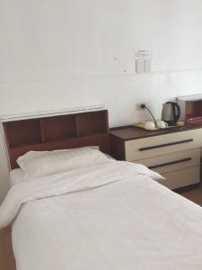 a bedroom with a white bed and a night stand at Meekatharra Hotel in Meekatharra