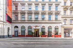 a large white building on a city street at Theaterhotel & Suites Wien in Vienna