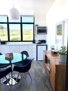 une cuisine avec une table et des chaises dans une cuisine dans l'établissement Karee Manor Guesthouse, à Stilbaai