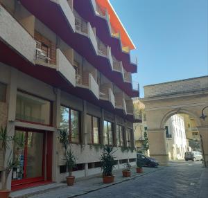 un bâtiment avec balcon et plantes en pot dans une rue dans l'établissement Hotel Colibrì, à Finale Ligure