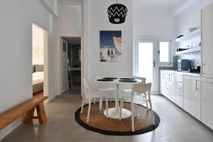 cocina blanca con mesa blanca y sillas en Armenistis 3, en Naousa