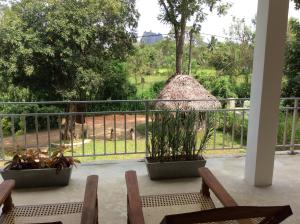 balcone con 2 sedie e vista su una giraffa di Sigiriya Rock Hide a Sigiriya