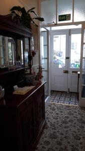 a kitchen with a sink and a mirror and a door at Branstone Guest House in Llandudno +34 photos