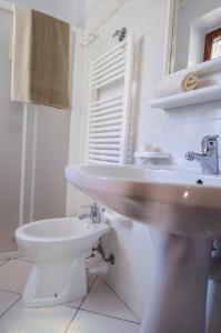 a white bathroom with a sink and a toilet at Casa Gelso in Marciana
