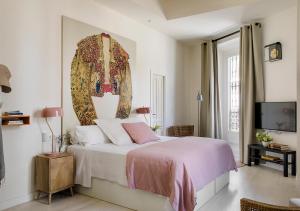 een slaapkamer met een bed met een schilderij aan de muur bij Santa Paula Pool & Luxury in Sevilla