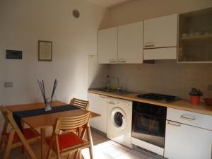 eine Küche mit einem Tisch und einer Waschmaschine in der Unterkunft MaremMare Tuscany Apartments in Principina a Mare + 44 Fotos