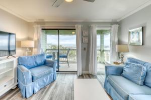 uma sala de estar com duas cadeiras azuis e uma mesa em Sea Cabin 347-C em Isle of Palms