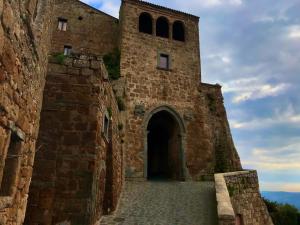 un gran edificio de ladrillo con una puerta grande en La Sorpresa Di Civita, en Bagnoregio