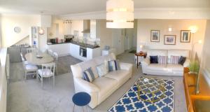 salon z kanapą i stołem oraz kuchnia w obiekcie Scarborough-Penthouse, with private balcony, lift and parking w Scarborough