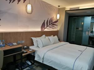 Postel nebo postele na pokoji v ubytování Guangzhou Homies Hotel