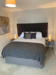 a bedroom with a large bed with two lamps on tables at Telford Townhouse with Parking in Telford
