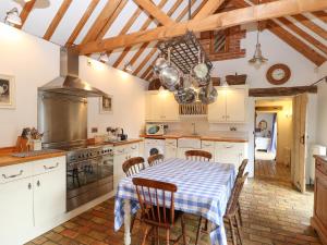 uma cozinha com mesa e cadeiras num quarto em Stable Cottage em West Bradenham