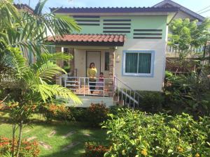 a woman standing on the front porch of a house at Montra Resort in Ko Larn