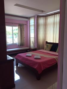a bedroom with a large bed with a red blanket at Montra Resort in Ko Larn