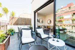 um pátio com cadeiras e mesas numa varanda em En Ville Boutique Apartments Sant Antoni em Barcelona