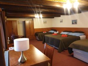 Habitación con 2 camas y mesa con lámpara. en Aaron en Praga