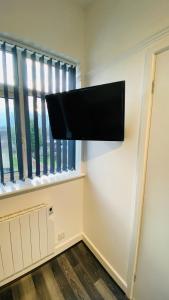 a flat screen tv on a wall next to a window at Small Self Contained Studio In Sutton Coldfield in Birmingham