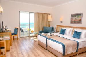 ein Hotelzimmer mit großem Bett und Balkon in der Unterkunft Korumar Hotel Deluxe in Kusadası
