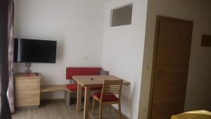 um pequeno quarto com uma mesa e uma televisão na parede em Weinbau Ettenauer em Rohrendorf bei Krems