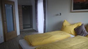 um quarto com uma cama com um cobertor amarelo em Weinbau Ettenauer em Rohrendorf bei Krems