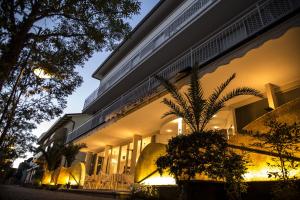 a building with a palm tree in front of it at Casa Portofino Rooms&Breakfast in Cesenatico